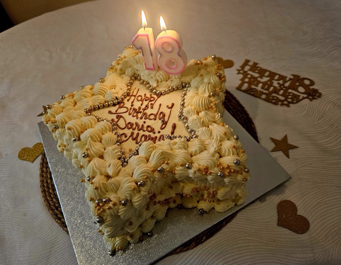 A star-shaped 18th birthday cake decorated with piped cream and gold and silver pearls, made at Delicio Patisserie