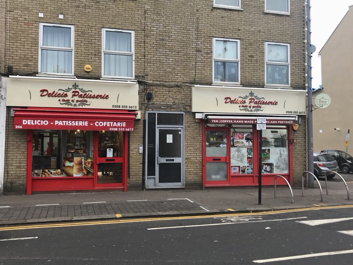 The red and cream shopfront of Delicio Patisserie on High Road, Leytonstone, with its 'a taste of quality' sign